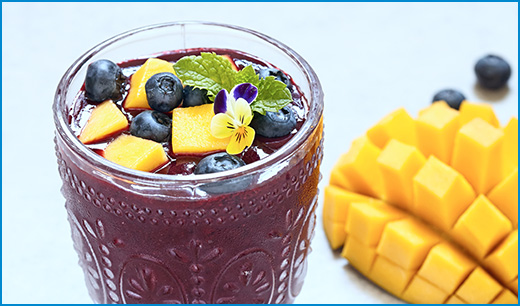 purple smoothie with chopped mango and blueberries